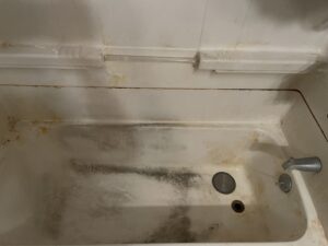 Before and after shower deep cleaning in Whitman, MA with rust stain removal.