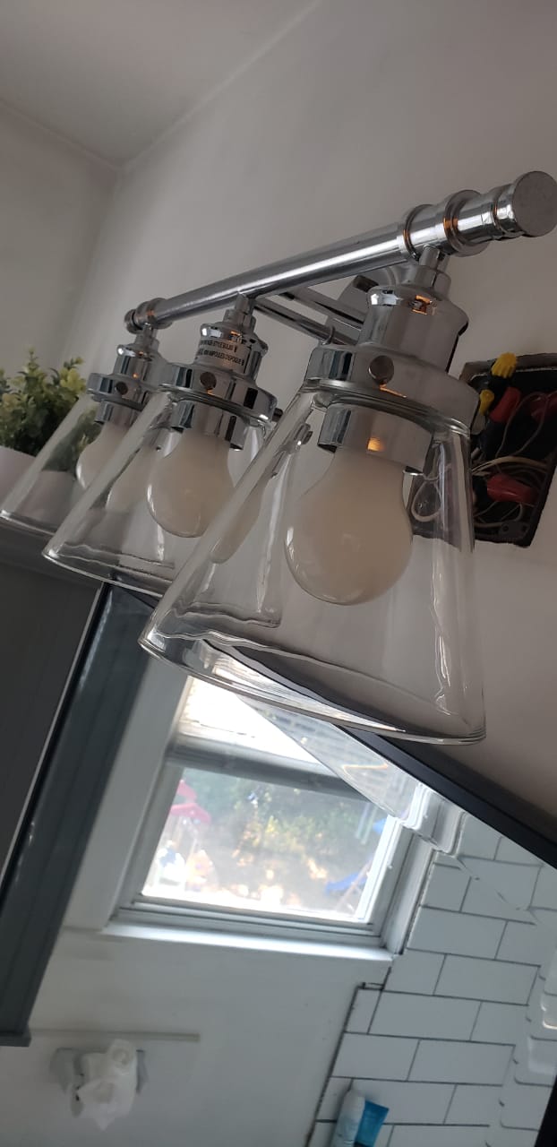 The same three-bulb light fixture with clear, clean glass shades after cleaning by Sirley Cleaning Services