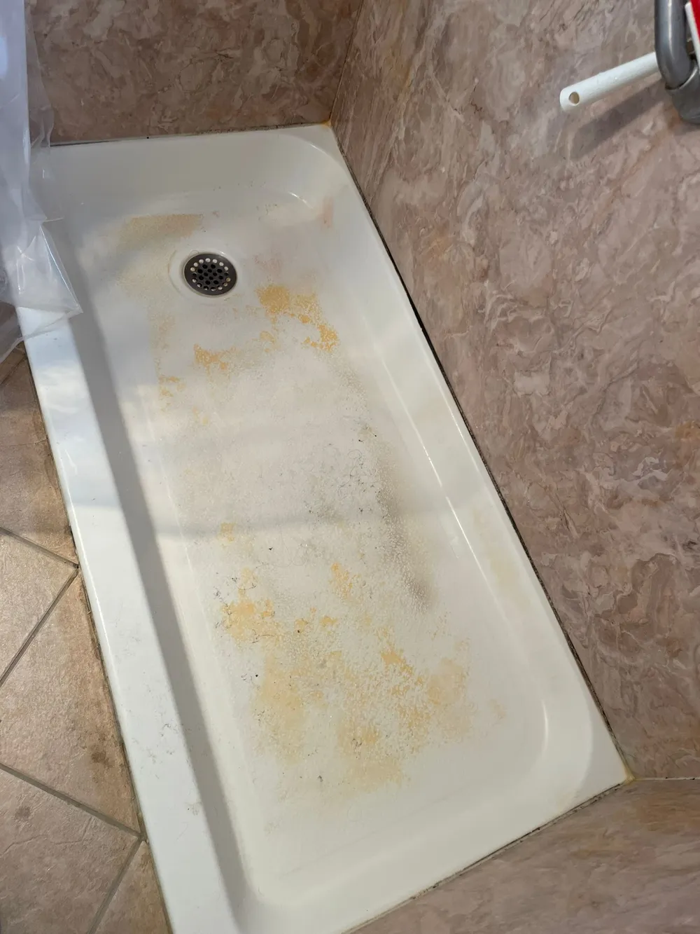 Stained shower pan before cleaning